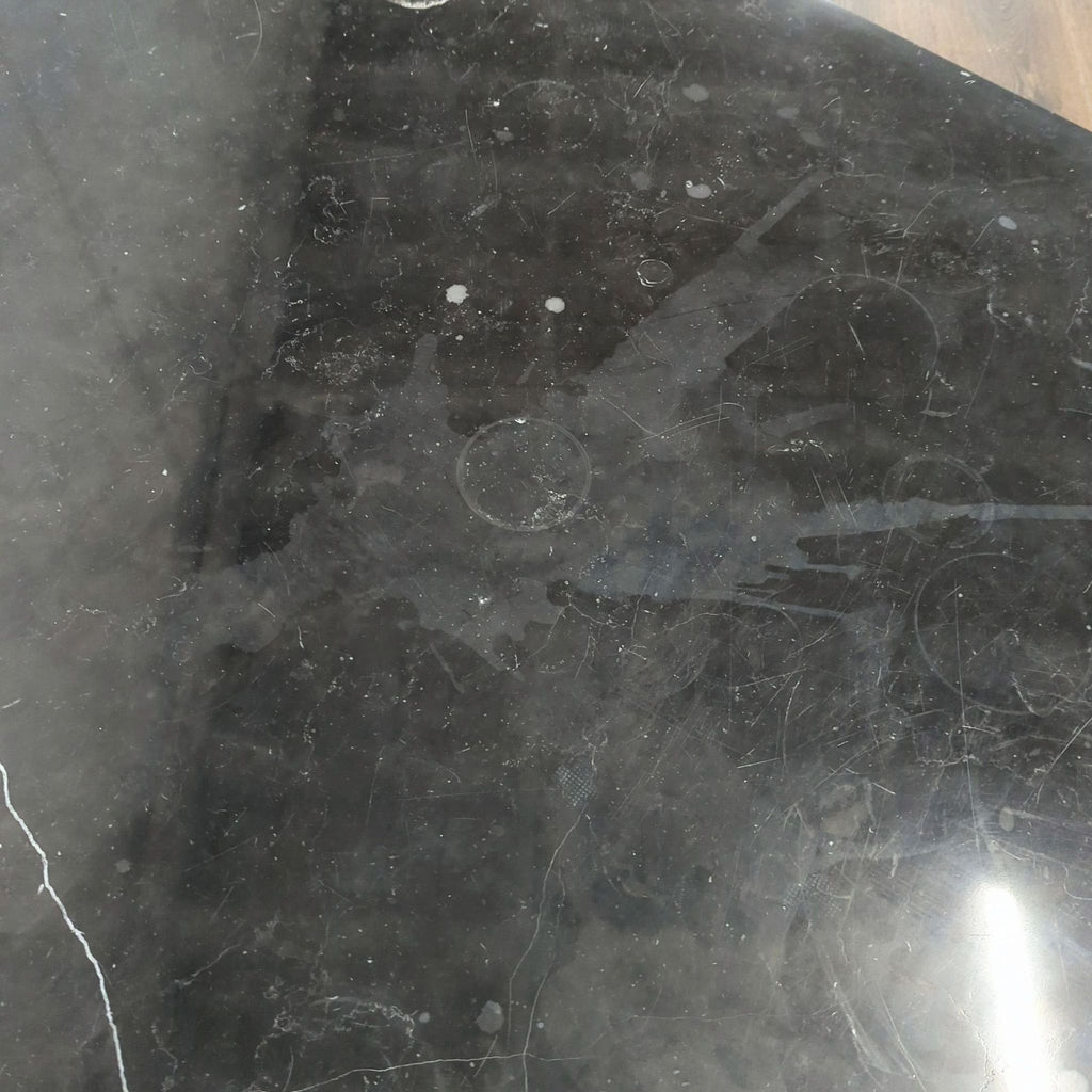 1. Close-up of Parsons Black Marble coffee table surface showing scratches, stains, and marble texture.