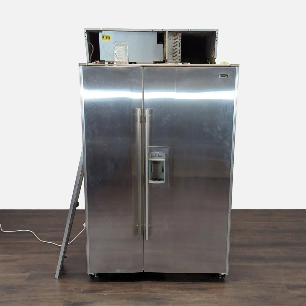1. Sub-Zero stainless steel side-by-side refrigerator with water and ice dispenser and minor cosmetic wear.