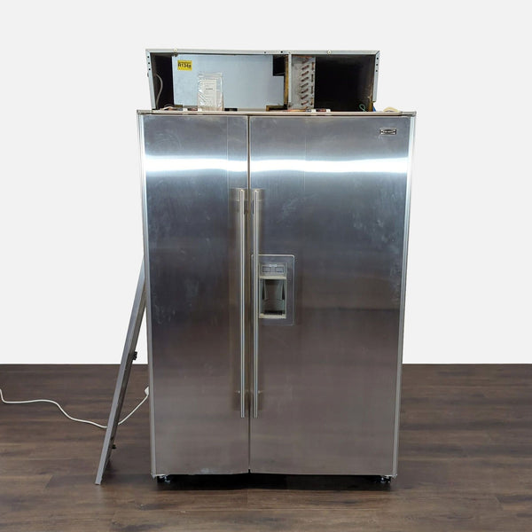 1. Sub-Zero stainless steel side-by-side refrigerator with water and ice dispenser and minor cosmetic wear.