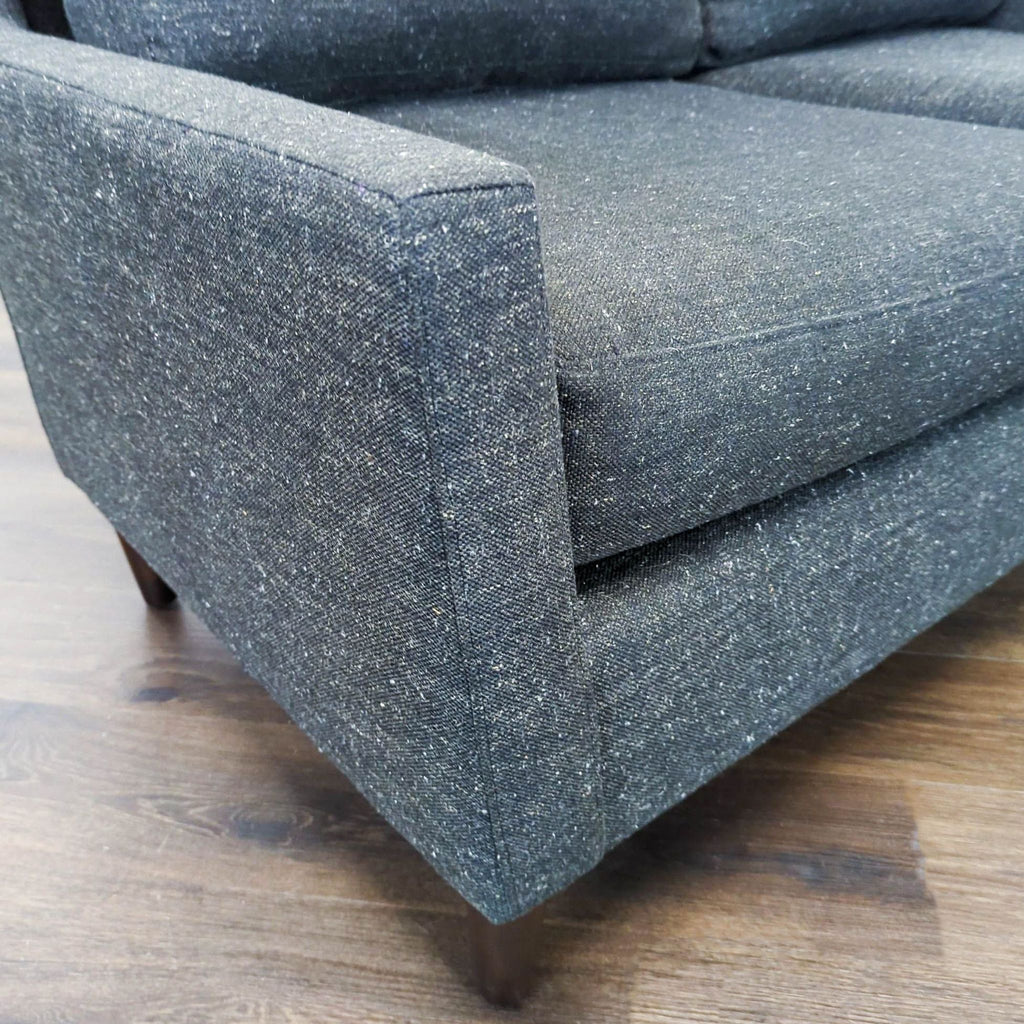 3. Close-up of the West Elm loveseat armrest, highlighting the fabric texture and stitching detail.