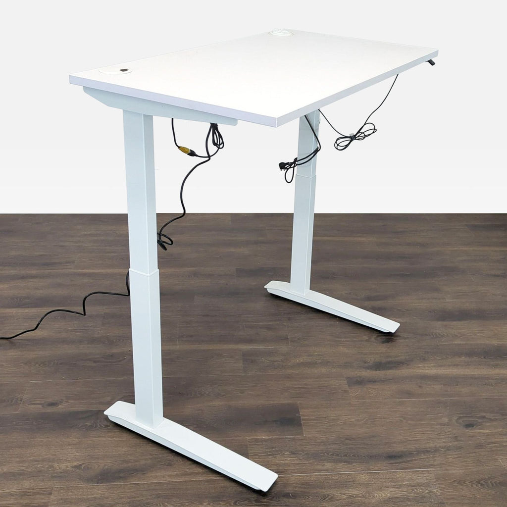 3. Full view of a white Fully adjustable standing desk with visible cords, positioned on a wooden floor.