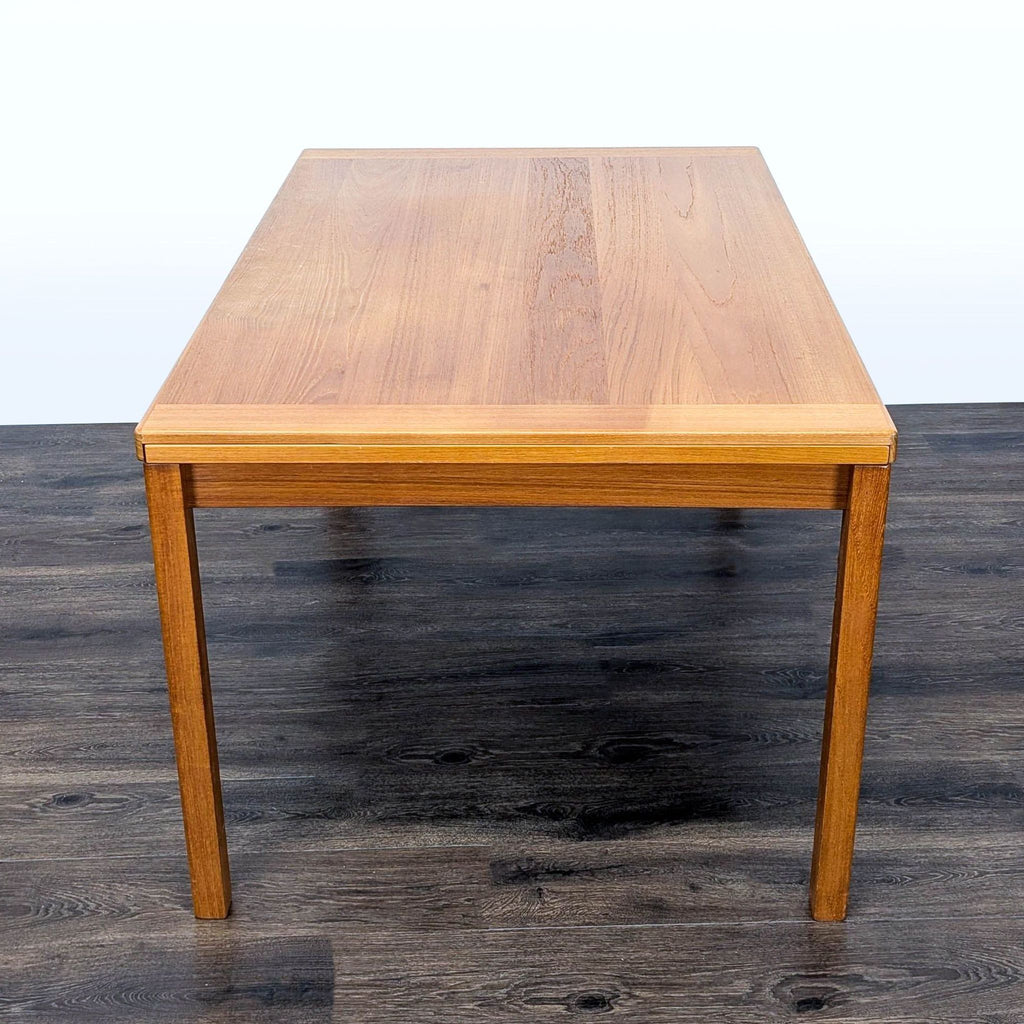 3. Side view of the Reperch dining table, leaves not extended, showcases elegant rectangular wood design.