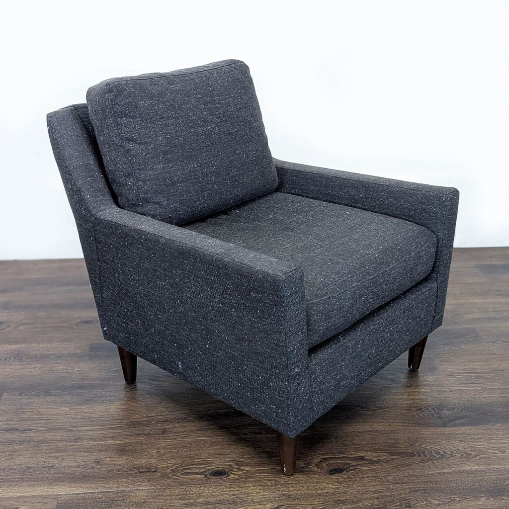 2. Angled side view of a modern West Elm lounge chair in dark fabric with cushioned seat and back, originally $500.