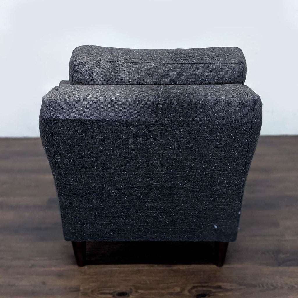 3. Rear view of a charcoal West Elm lounge chair with clean, modern lines and plush back cushion, lounge category.