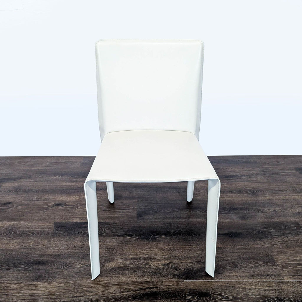 1. Modern white chair with straight backrest and sleek design, shown on dark wood floor, brand B&B Italia.