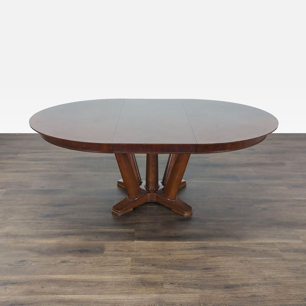 1. Oval wooden dining table with central pedestal base by Mitchell Gold + Bob Williams on wood flooring.  