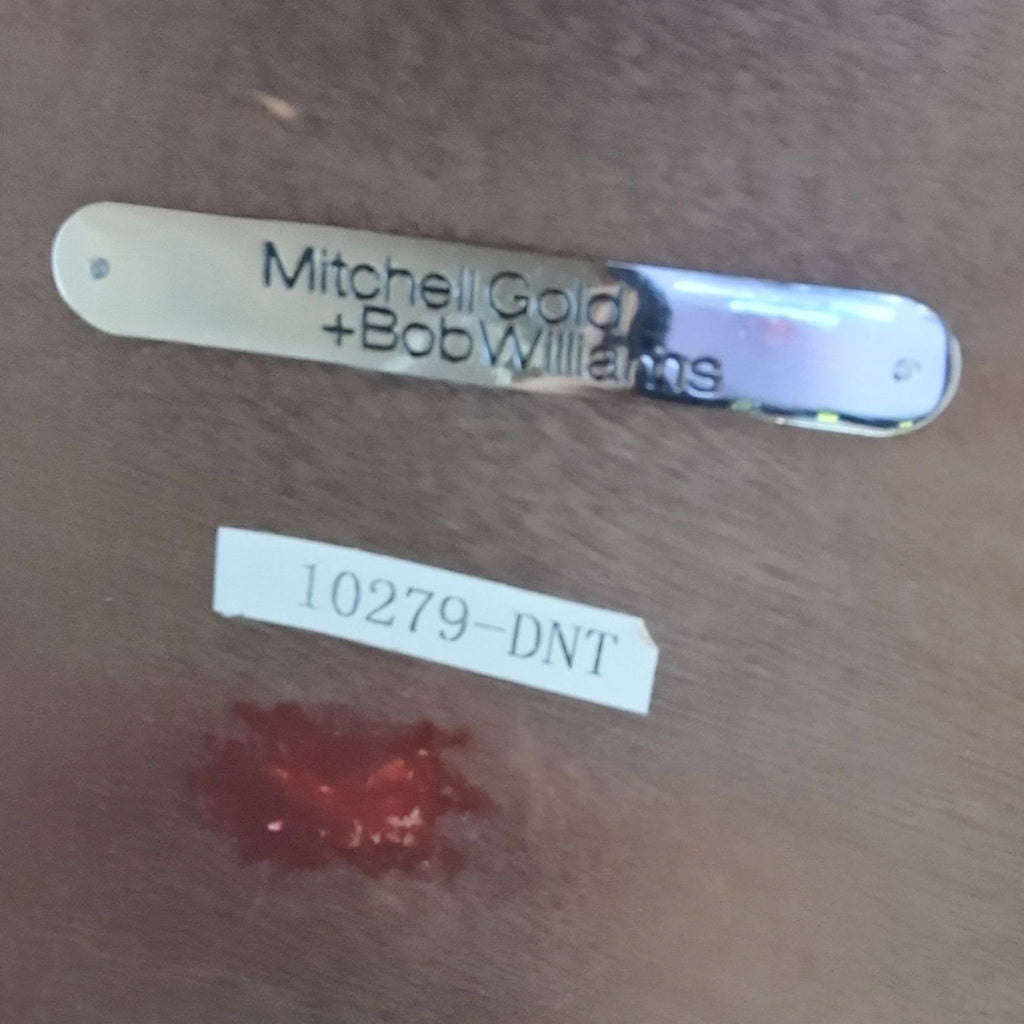 2. Close-up of Mitchell Gold + Bob Williams brand tag and model number label on a wooden surface.  
