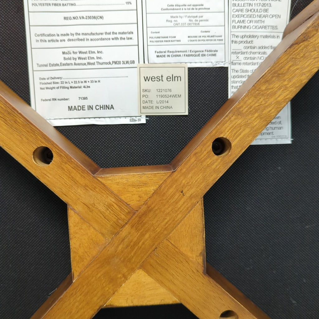 3. Underside of a West Elm dining chair, showing wooden frame construction and manufacturer labels.