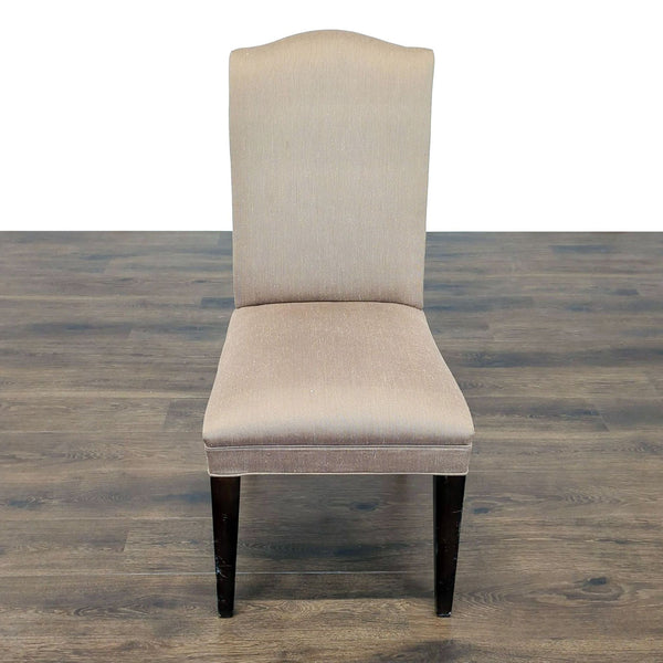1. Beige upholstered dining chair with dark wooden legs by Mitchell Gold + Bob Williams on wood flooring.