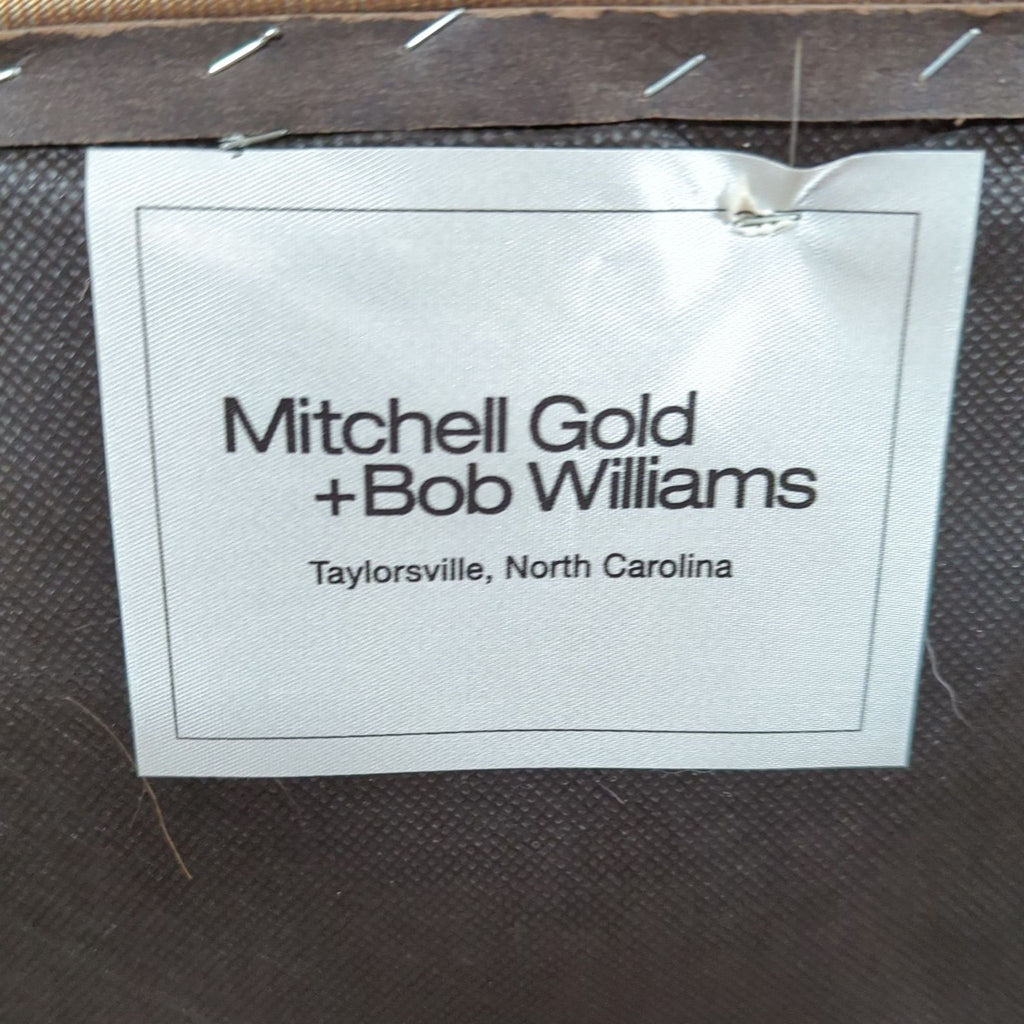 2. Manufacturer label showing "Mitchell Gold + Bob Williams, Taylorsville, North Carolina" on the chair’s underside.