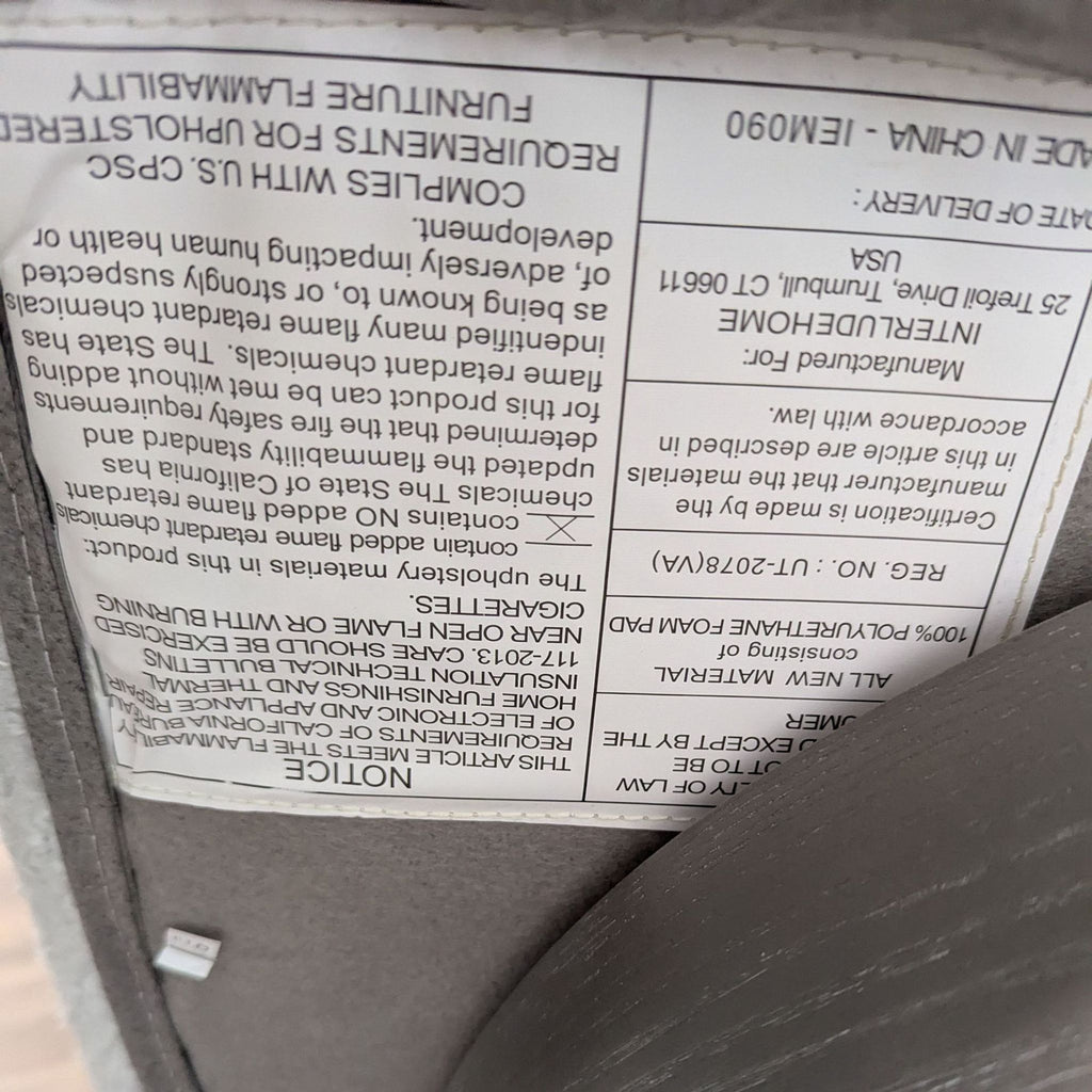 Close-up of the product label from Interlude Home with care instructions and manufacturing details, lounge item.  