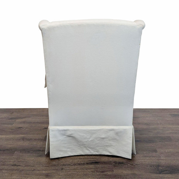 1. Back view of an Ethan Allen lounge chair with a white fabric slipcover, shown on a dark wood floor.