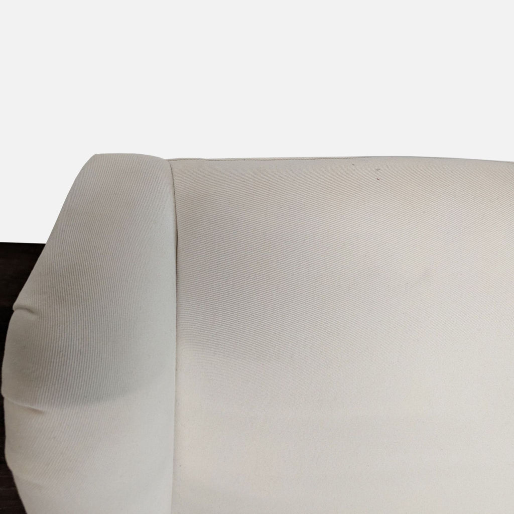 2. Close-up of the upper back and rolled armrest of an Ethan Allen white lounge chair in fabric upholstery.