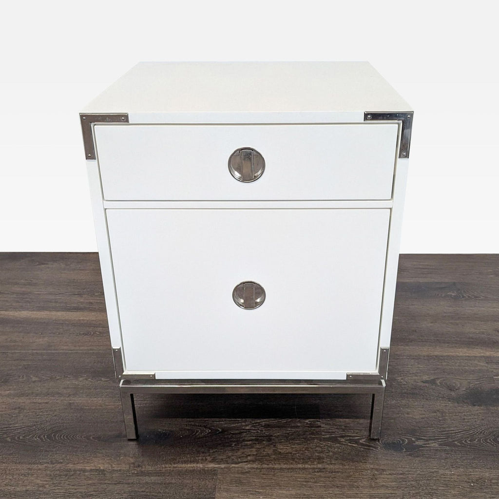 Front view of a West Elm end table in white lacquer with polished nickel hardware and campaign-style details.  