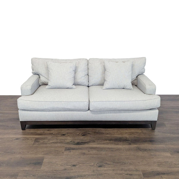 Light gray Ethan Allen 3-seat sofa with a wood base, tapered legs, loose cushions, and track arms, front view.