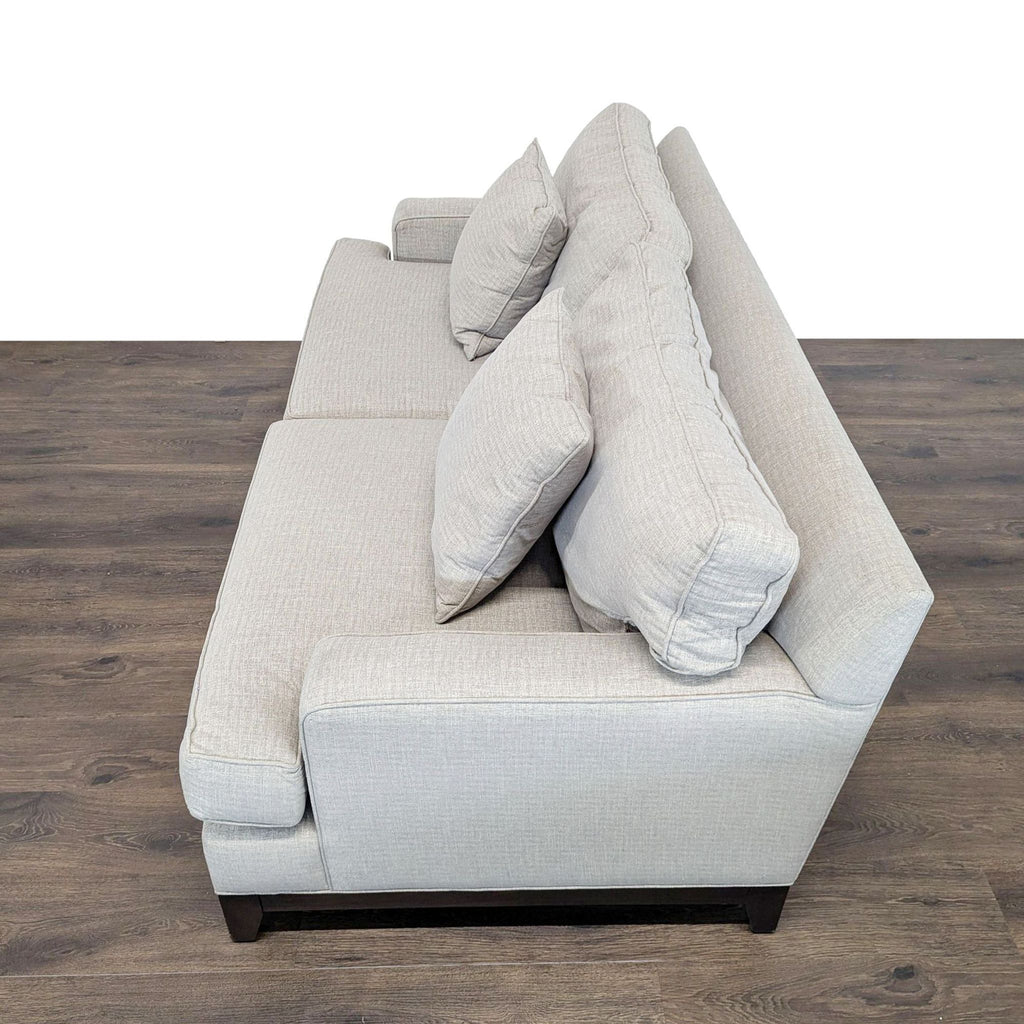 1. Side view of an Ethan Allen 3-seat sofa in light gray fabric with two matching cushions on wood flooring.  