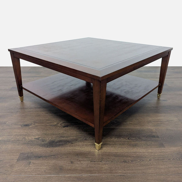 1. Square Reperch coffee table in dark wood finish with lower shelf and gold-tipped legs on wood floor.