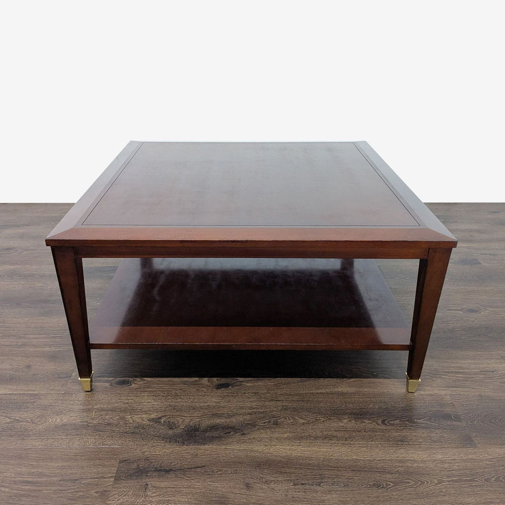 1. Square Reperch coffee table in dark wood with lower shelf and brass-capped legs, shown on wood flooring.  