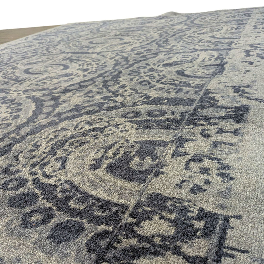 1. Close-up of a Pottery Barn rug showing its intricate blue and grey patterned texture.