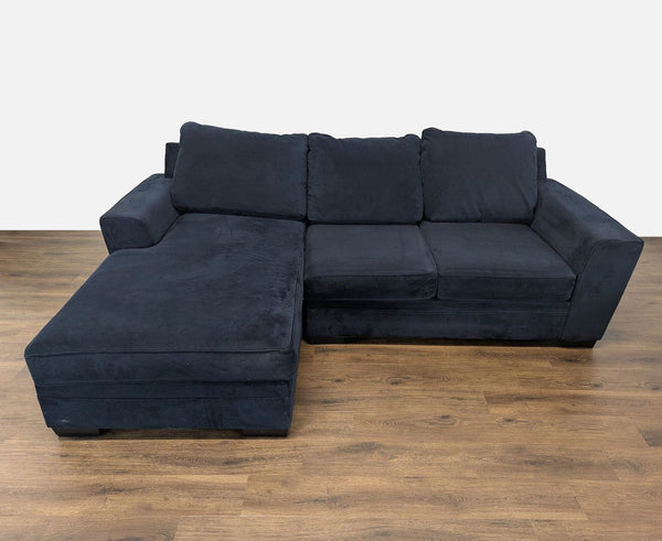 1. Living Spaces sectional sofa with track arms, tapered legs, and a reversible chaise in a dark fabric.
