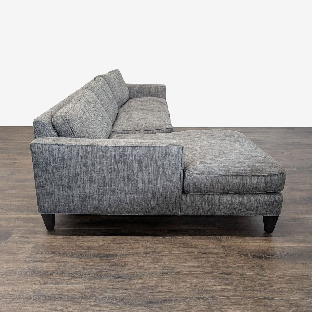 Modern Room and Board sectional featuring track arms, tapered wooden legs, and an attached chaise.