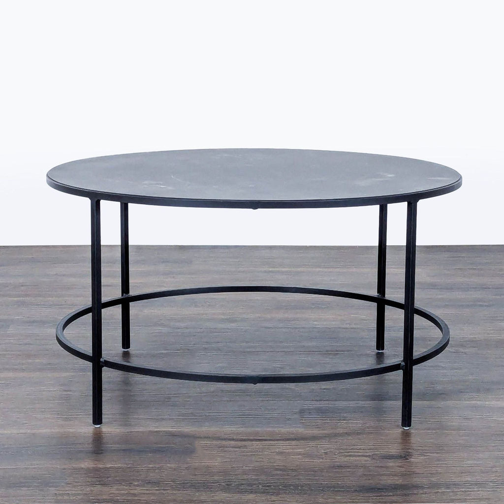 1. Room & Board coffee table made of powder coated steel in a slate finish, featuring a modern round design.  