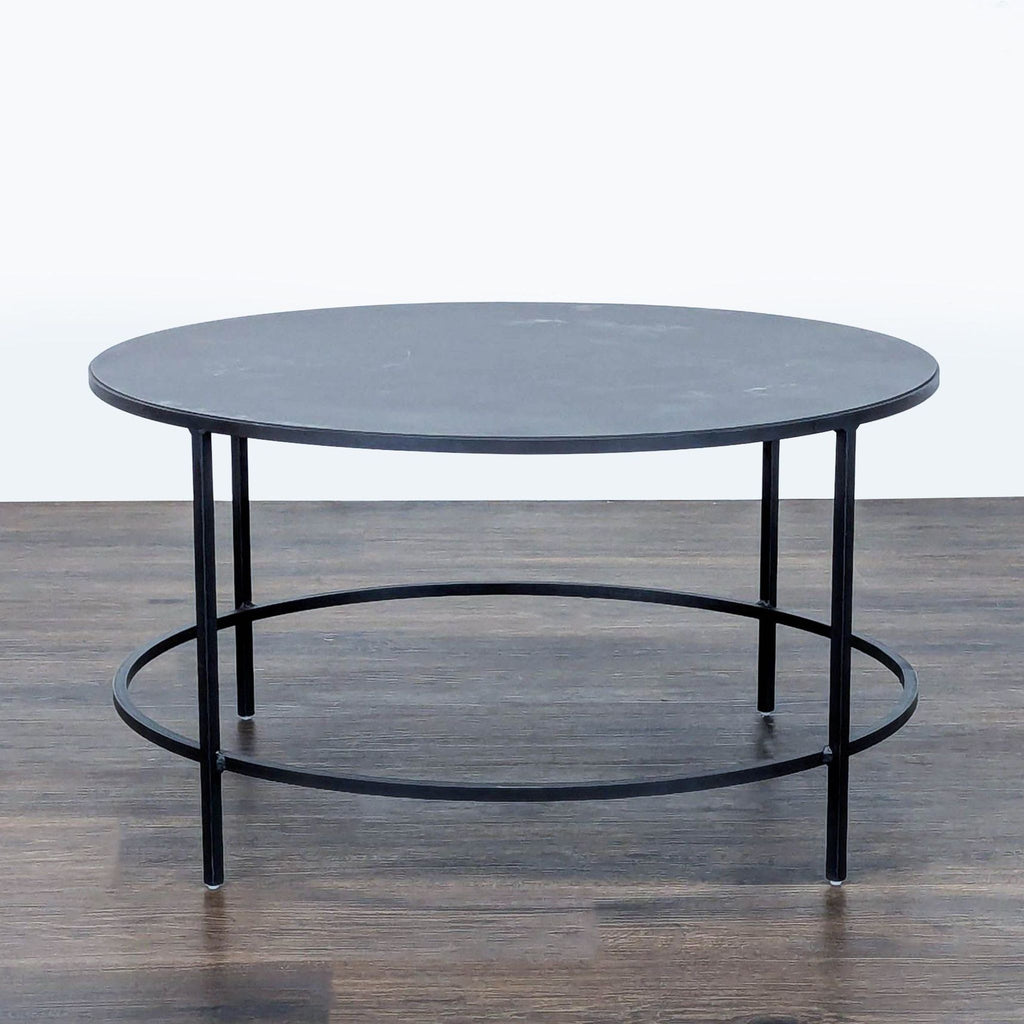3. Round Room & Board coffee table in slate powder coated steel, minimalistic with four slim legs and open base.
