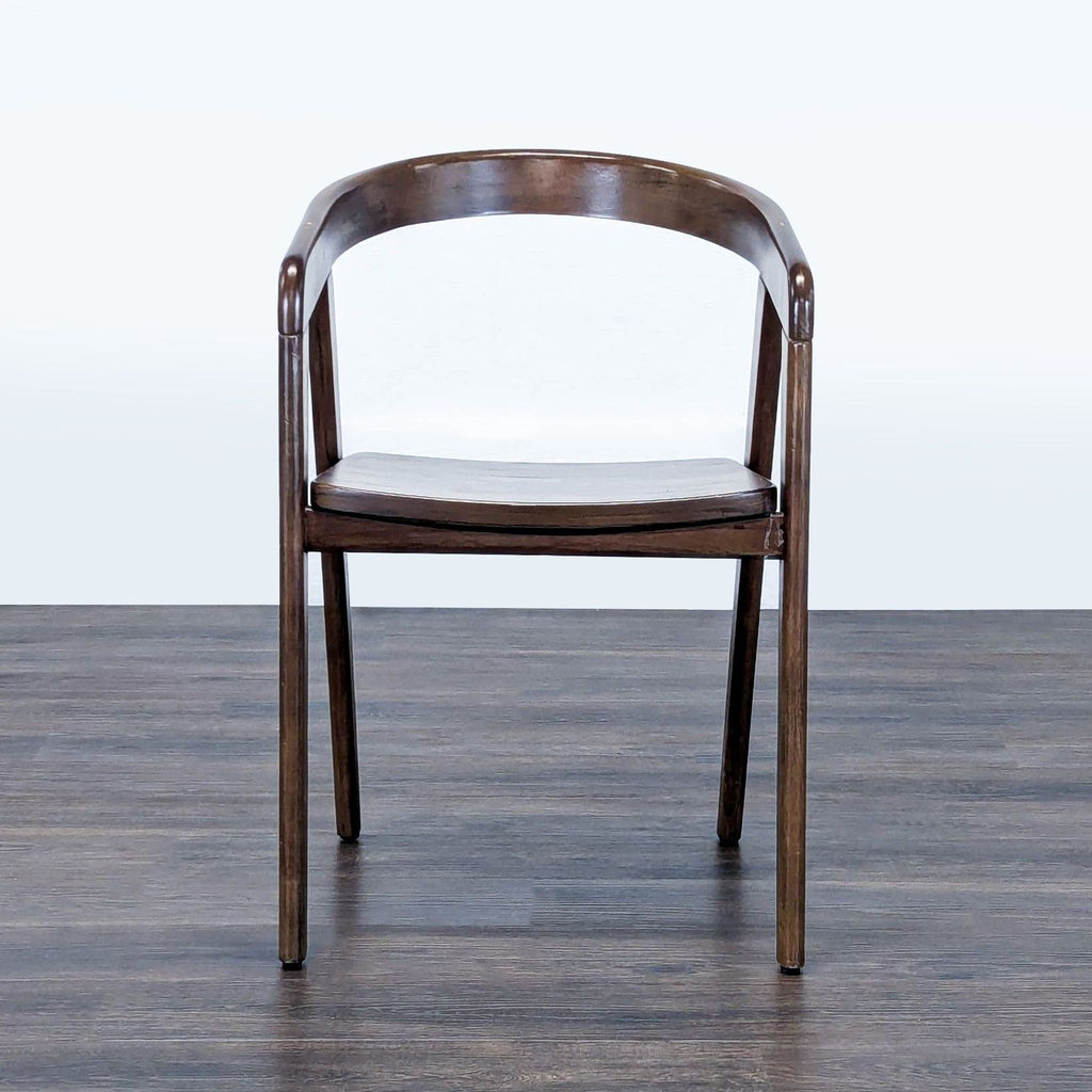 Front view of a Reperch dining chair with a rounded wooden back and a slightly contoured seat.