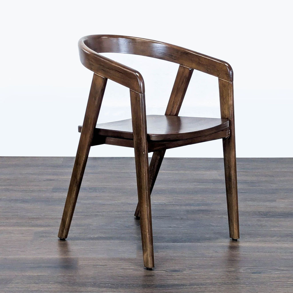 Angled side view of a Reperch dining chair showing the curved back, sturdy legs, and rich wood finish.