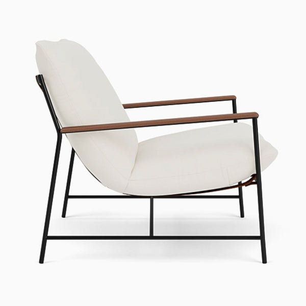 1. Side view of a Denver Modern lounge chair with white cushions, slim black metal frame, and wooden armrests.