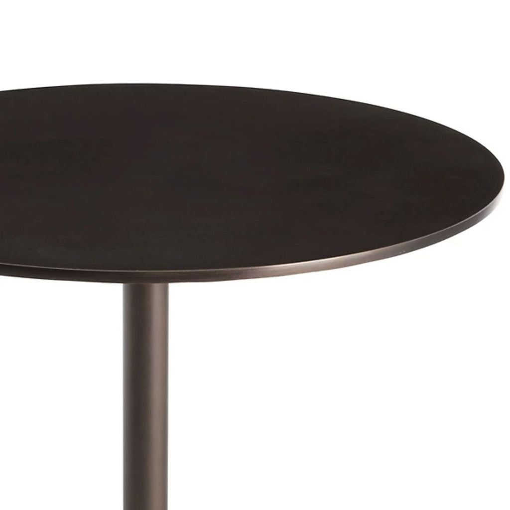 2. Close-up of a round, dark metal tabletop from an Arteriors Home side table with a modern minimalist design.  