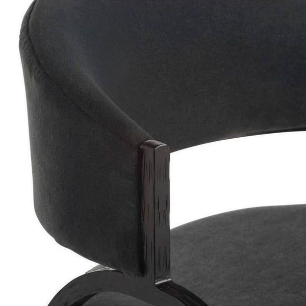1. Close-up of a black lounge chair by Arteriors Home, highlighting the curved velvet backrest and arm detail.