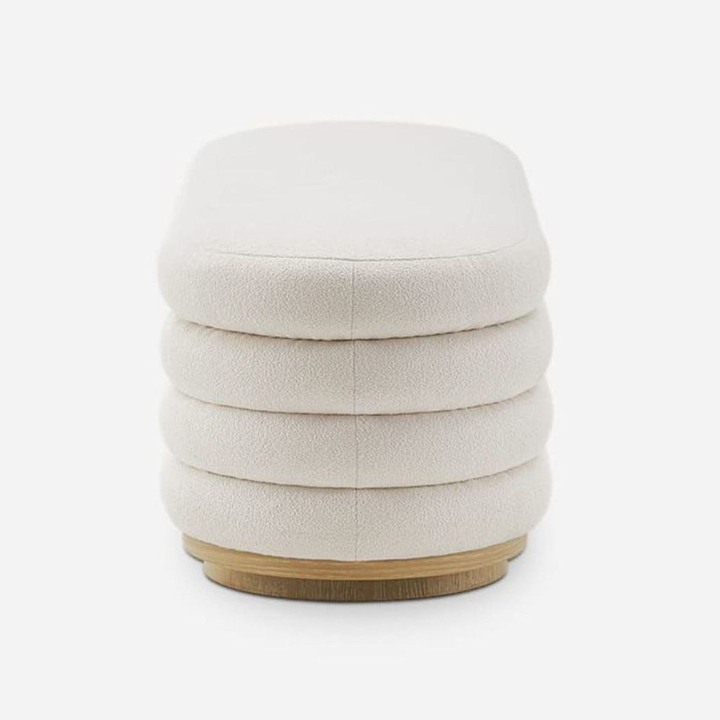 3. End view of Castlery channel-tufted boucle bench showing layered upholstery and circular wood base.