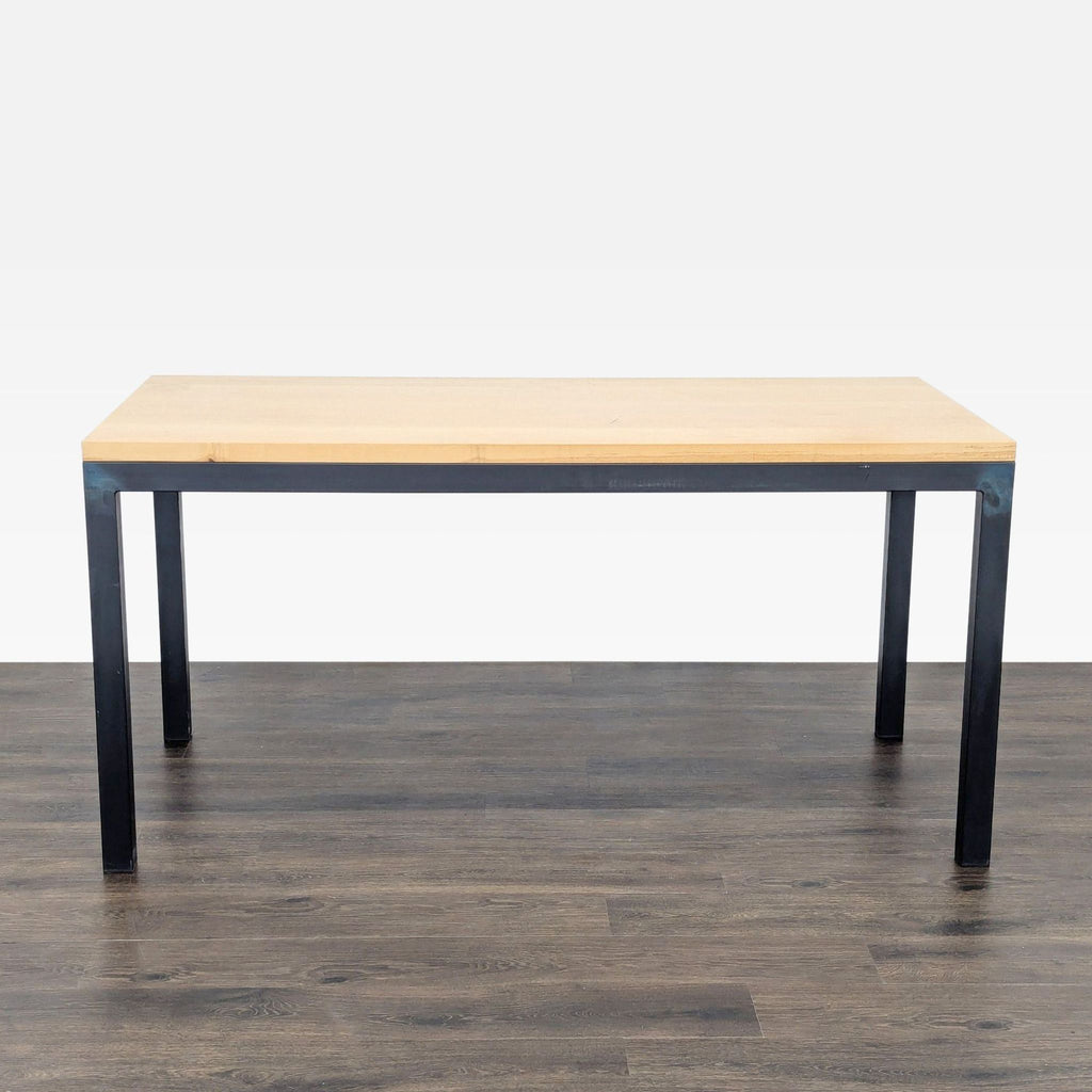 Rectangular dining table with a maple top and natural steel legs by Room & Board, on a wood floor.  