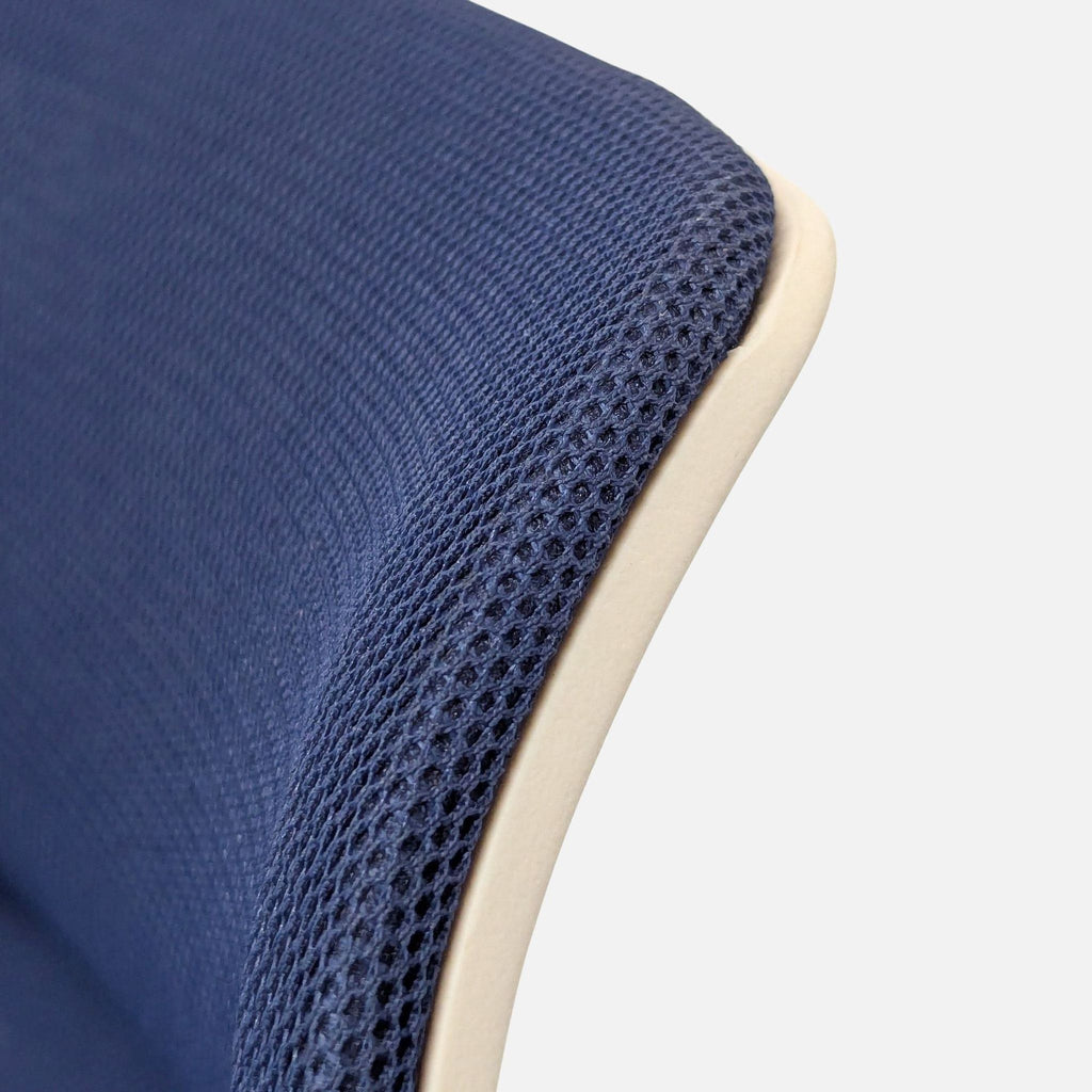 Close-up of the blue mesh fabric and frame detail on the Uplift ergonomic office chair's backrest.