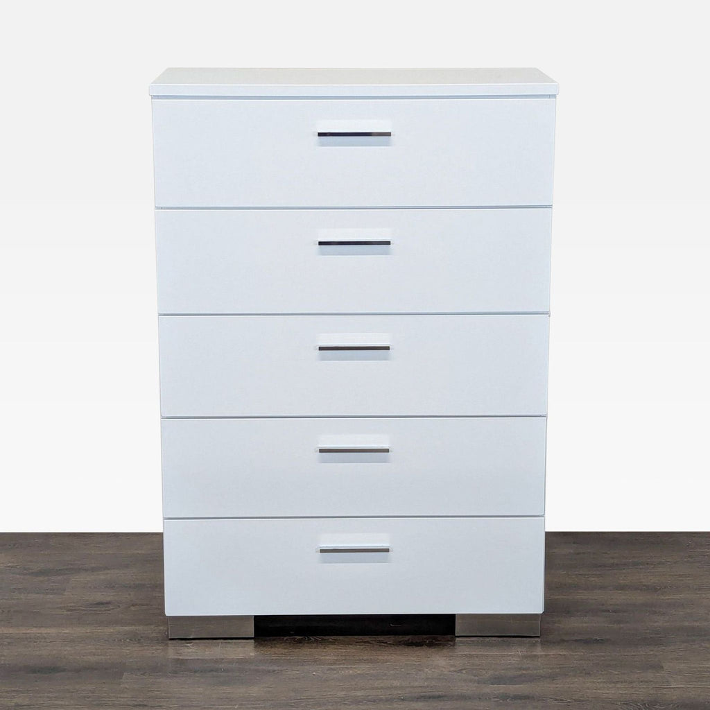 1. Front view of a modern white Coaster dresser with five drawers and chrome handles, on a wood floor.