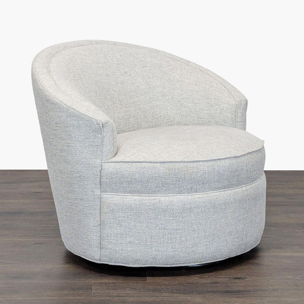 1. Light gray Reperch lounge chair with rounded back and base, upholstered in soft fabric, on dark wood floor.