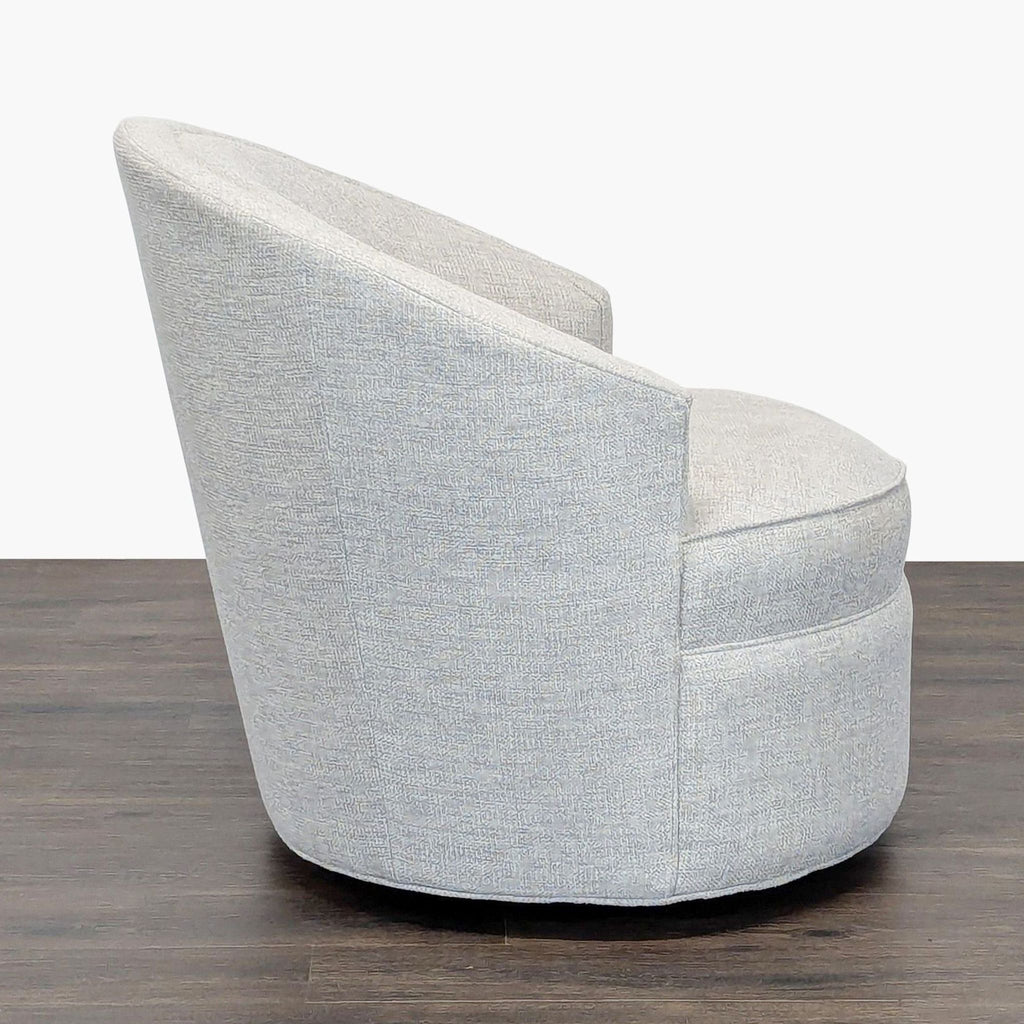 3. Side profile of a contemporary Reperch lounge chair, featuring a sloped rounded back and textured gray fabric.