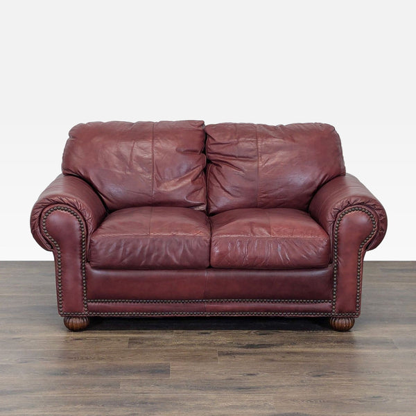 1. Front view of a classic leather loveseat by Viewpoint Leather Works, featuring rolled arms and studded accents.  