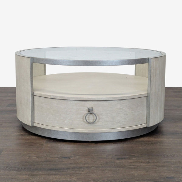 1. Round Reperch coffee table with glass top, lower shelf, and a front drawer on dark wood floor.