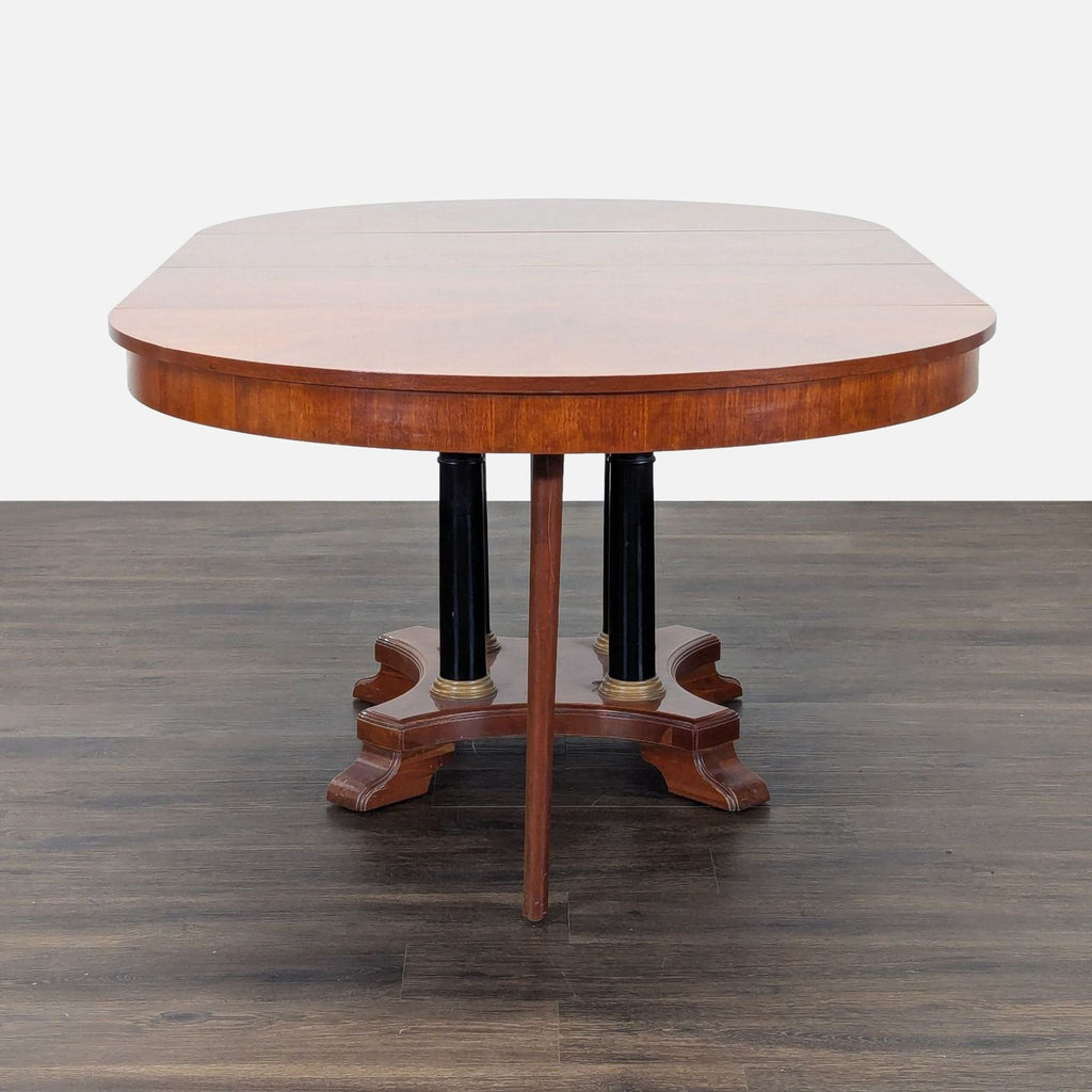 Circular table with two leaves to make two different sized ovals. 2 armed host chairs and 5 other chairs. Also 1 damaged chair which could be repaired. 
One leaf is installed. 
View of legs and base. 
Showing leaf mechanism. 
Side chair and host chai
