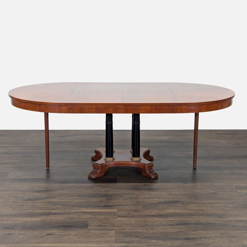 3. Front view of Ethan Allen dining table in oval shape, pedestal base and support legs visible, with leaf inserted.