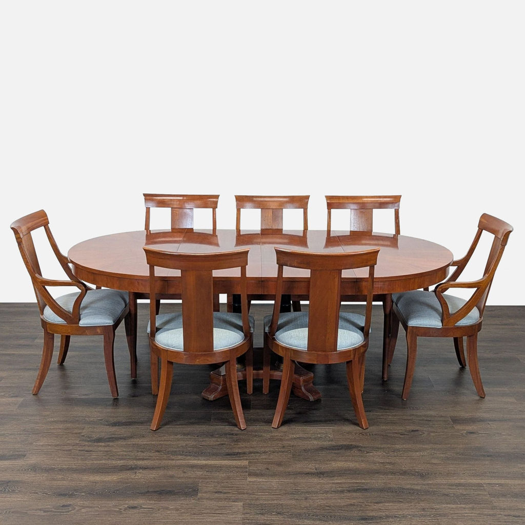 Circular table with two leaves to make two different sized ovals. 2 armed host chairs and 5 other chairs. Also 1 damaged chair which could be repaired. 
One leaf is installed. 
View of legs and base. 
Showing leaf mechanism. 
Side chair and host chai