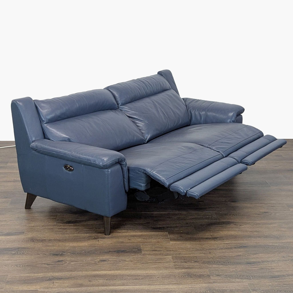 Front angled view of a blue Reperch couch with both sides reclined, nearly flat, on wooden floor.