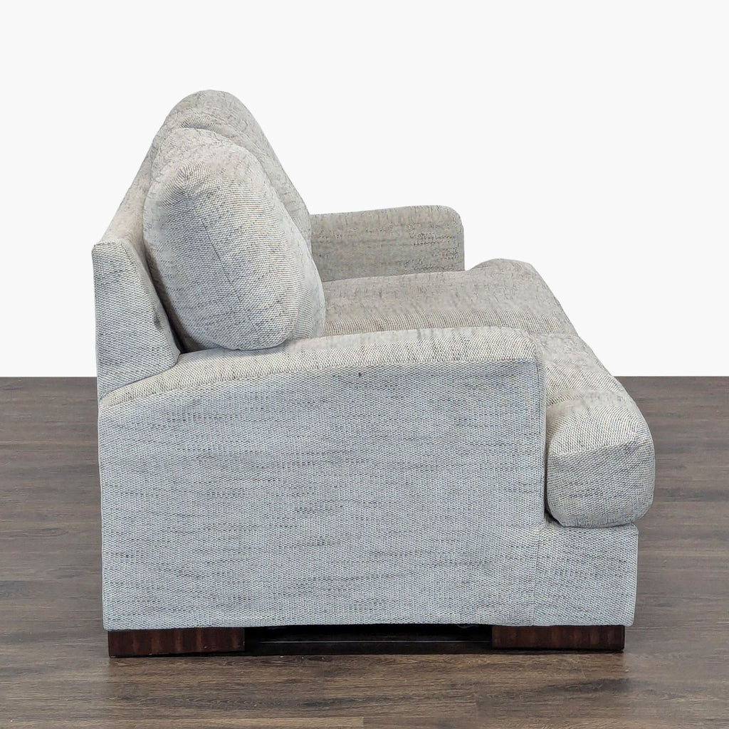 2. Side profile of a soft gray Ashley Furniture loveseat showing thick cushions and simple, modern design.