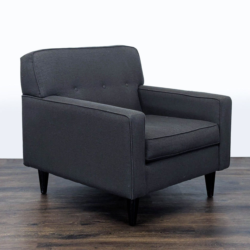 2. Angled side view of the Max Home lounge chair showing its boxy arms and modern dark upholstery.  