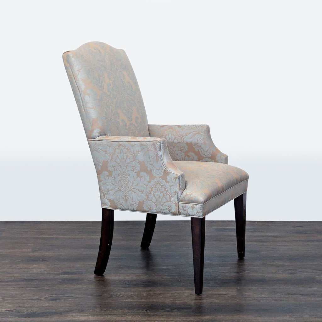 2. Side angle of a patterned Mitchell Gold + Bob Williams upholstered armchair with dark wood legs.