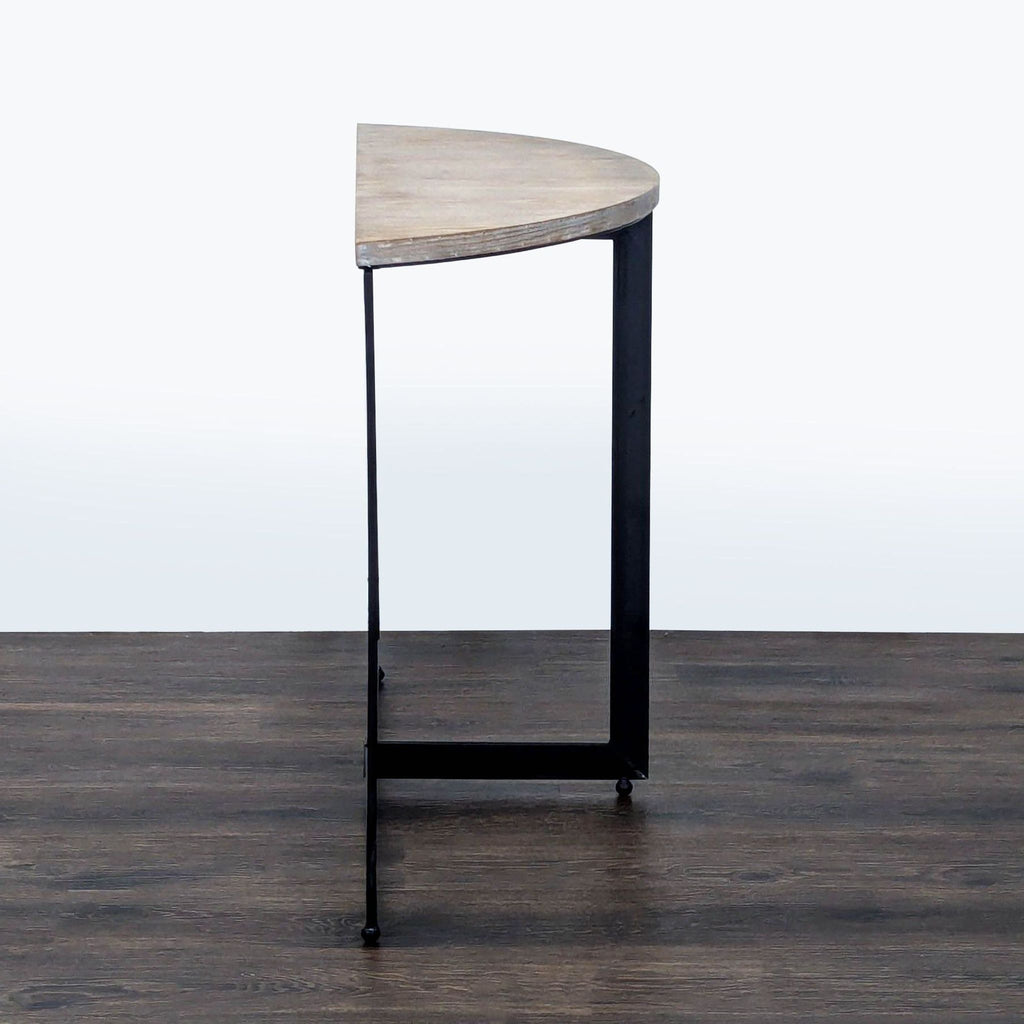 3. Minimalist Mercana side table, semi-circular wood top and sturdy black metal frame, viewed from the end.