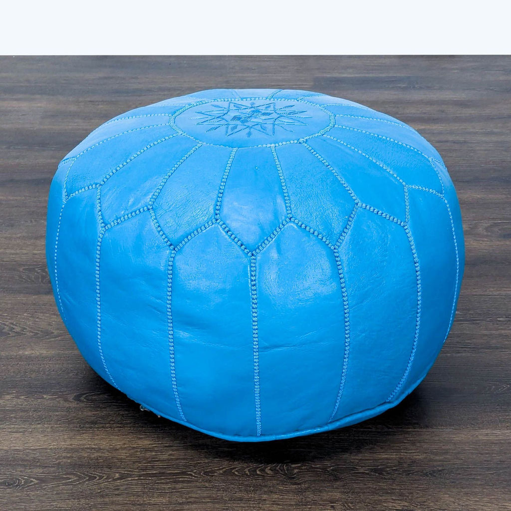 Reperch brand blue leather pouf with decorative stitching, ideal for use as a stool, ottoman, or bench.