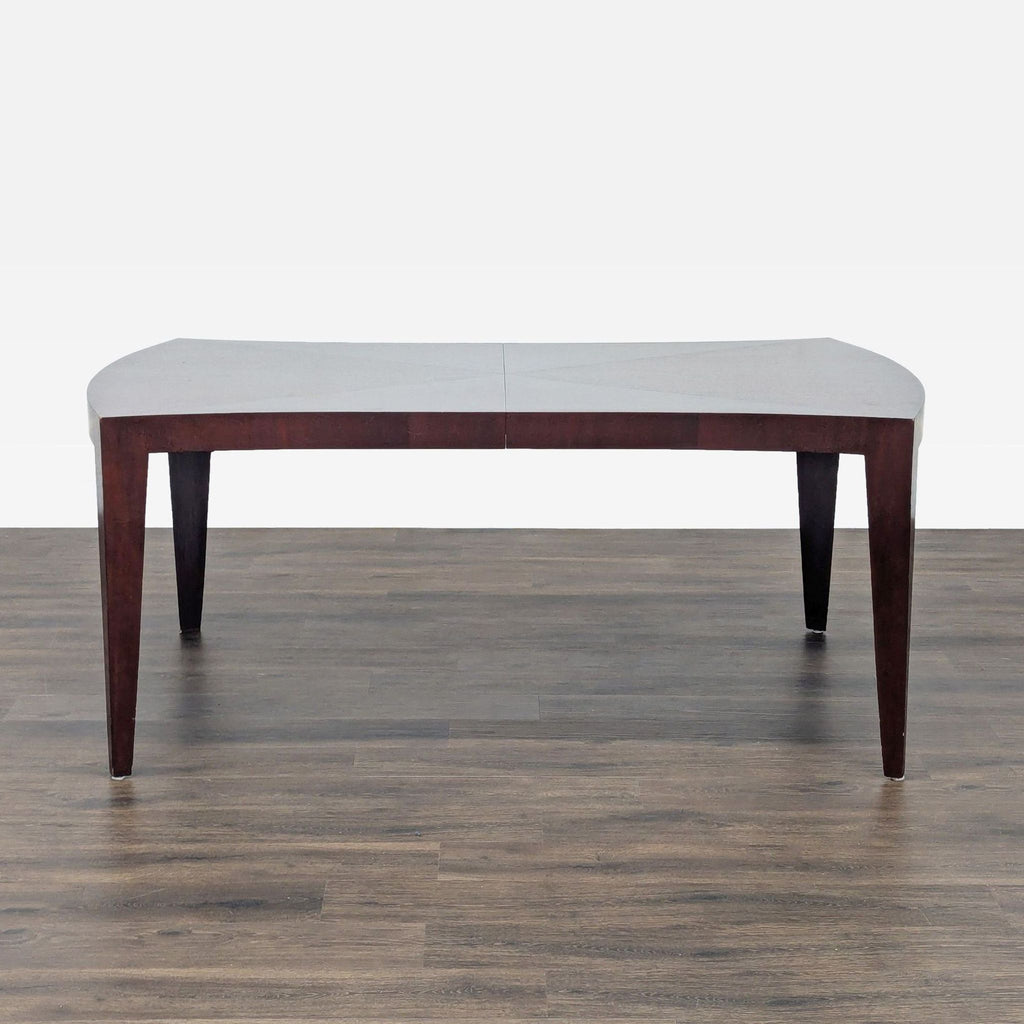 2. Front view of a New Studio dining table showing tapered legs and a gently curved rectangular top.